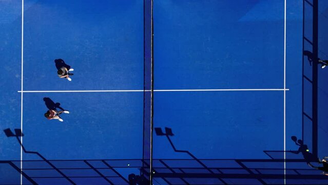 Aerial top view shot of padel tennis players playing on the court in summer. Competition of padel tennis.