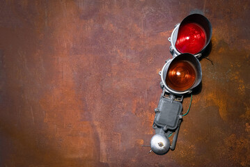 Old railroad traffic light on the rusty metal sheet background. Flat lay. Top view.