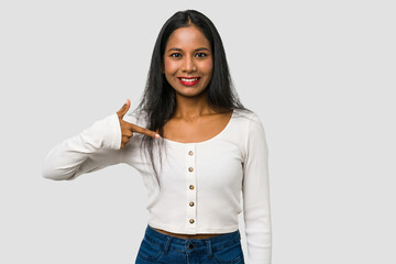 Young Indian woman cut out isolated on white background person pointing by hand to a shirt copy space, proud and confident