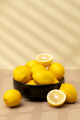  Still life yellow ripe lemons in a ceramic plate with a sprig of mint on the table. Copy space