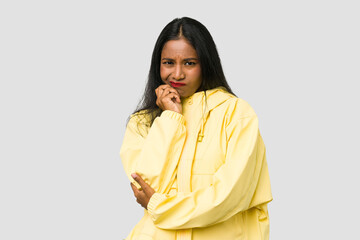 Young Indian woman cut out isolated on white background biting fingernails, nervous and very anxious.