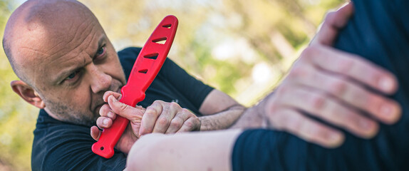 Knife attack self-defense. Techniques of disarming knife attacker. Weapon disarm training