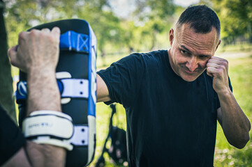 Muay thai trainer holds focus mitts. Kick boxing training and demonstration with pads. Martial arts...