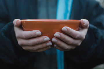 A woman's hands hold empty ceramic bowl.