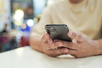 Relaxed young asian man using smart phone  spending time checking news social media.