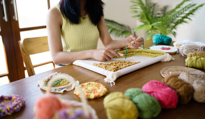 Punch needle. Asian Woman making handmade Hobby knitting in studio workshop. designer workplace...