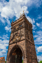 Medieval Old Town Bridge Tower among clouds, erected in 1385 and completed in 1878 at the entrance of the famous Charles Bridge in Prague