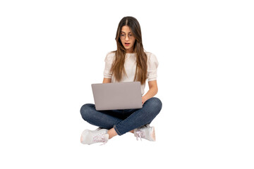 Shocked young woman, full body shot  of shocked young woman. Sitting on the floor, using laptop. Lifestyle concept. Holding notebook. Surprised by what she saw on the social media. Copy space. 