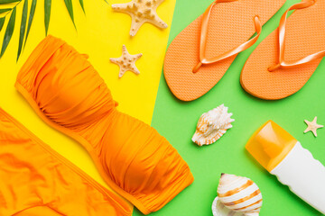 Woman swimwear and beach accessories flat lay top view on colored background Summer travel concept. bikini swimsuit, straw hat and seasheels. Copy space Top view