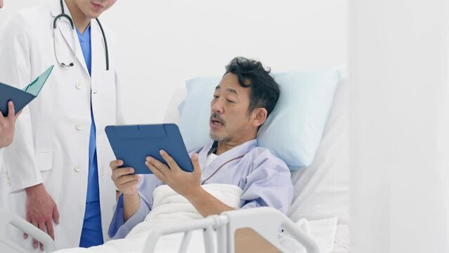 病室で患者に病状を説明する医師
