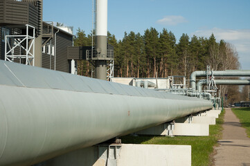 pipeline, factory in the background, forest and blue sky