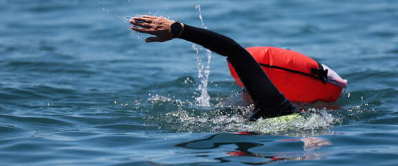 Long distance swimming marathon swimmer in action. Swimming man in clean ocean water. Open water swimming