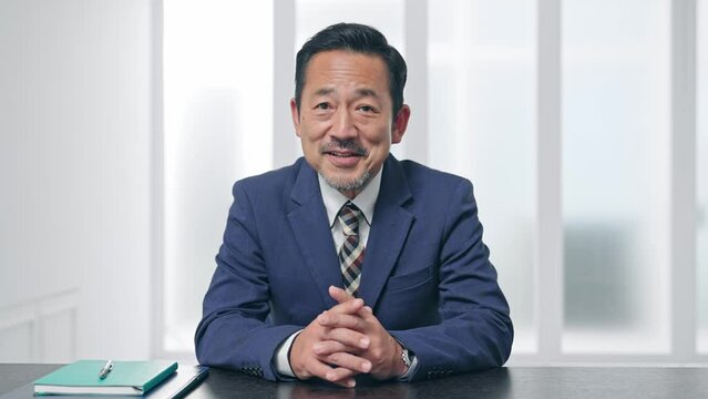 カメラ目線で話すビジネスマン　ビデオ通話　インタビュー