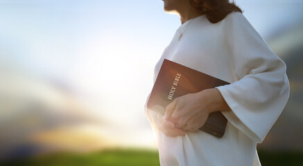 Christian background and worship and evangelism concept with church hand holding holy bible and...