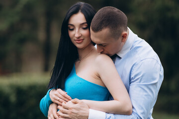 A young man kisses his pregnant wife in the stomach with care. place to copy