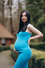 A modern pregnant woman, smiling, happy to be pregnant.