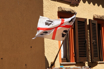 A Flag of Sardinia is blowing in a narrow alley at Castello dei Doria (Castle of Doria), Sardinia