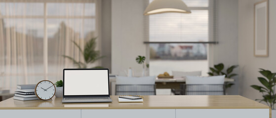 A laptop mockup on a wooden table over blurred background of a beautiful dining room.