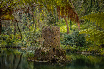Beautiful lake with small castle tower in the Pena natural park, Sintra, fairy tale green forest...