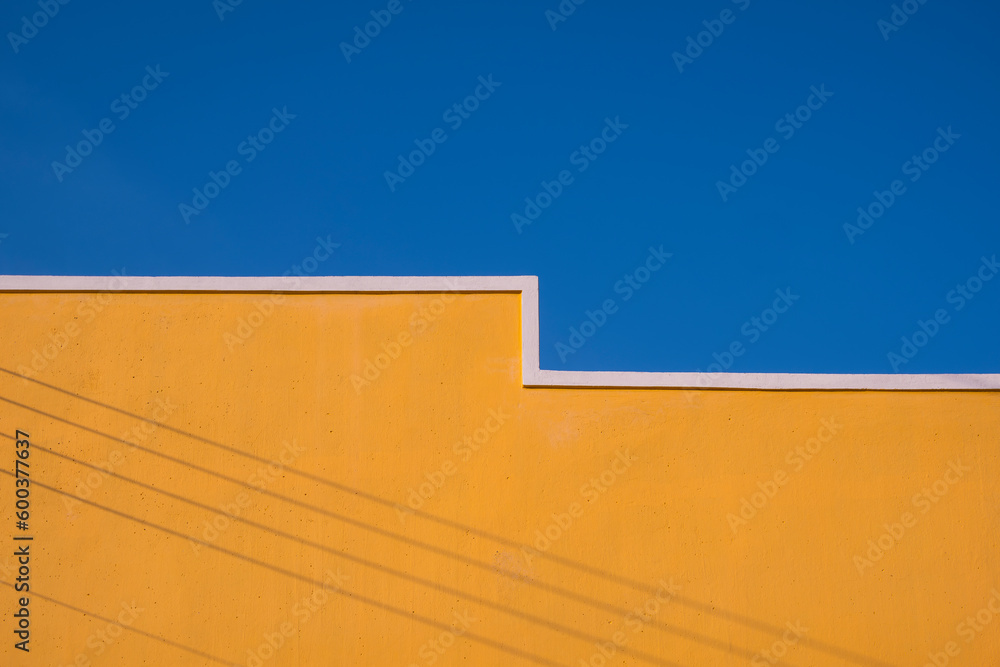 Wall mural minimal exterior architecture background of yellow building wall with shadow of electric cable lines