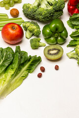 Set of vegetables, fruits and lettuce leaves on a white background.