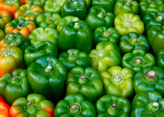 Obraz na płótnie Canvas A closeup of green bell peppers in a food market. 