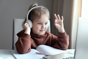 Caucasian girl studies online.Girl in headphones looking to laptop.The language of the dumb, finger spelling.Non-verbal communication.