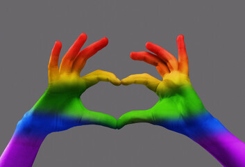 Human hands with rainbow light on it showing heart shape over grey background. Freedom of love, choice, support. Concept of freedom, lgbt, choice, human relation, community, togetherness, symbolism