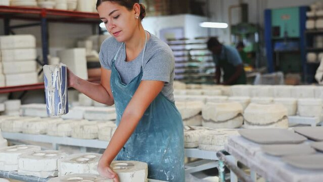 Pouring slip mass into plaster molds at a pottery factory. High quality 4k footage