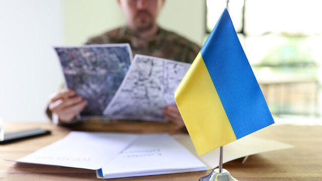 Military man holding in hands secret plans of Ukrainian counteroffensive operation closeup