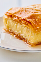 close up of a piece of galaktoboureko on a white plate