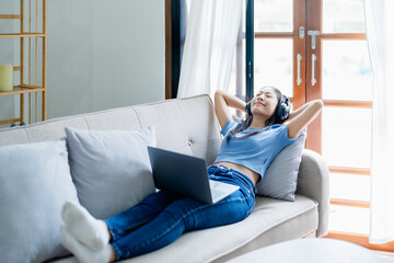 Home lifestyle woman relaxing sleeping on sofa  patio living room. Happy lady lying down on comfortable pillows taking a nap for wellness and health. Tropical vacation.