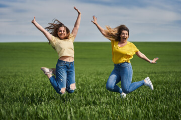 Plus size girls jumping for joy in a wheat field