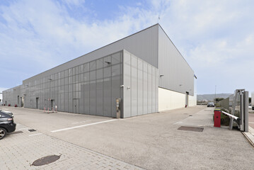 Fototapeta na wymiar Industrial building facade with outdoor parking spaces