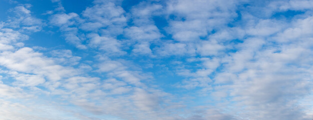 Blue sky with white cirrus clouds, wide panorama of the sky