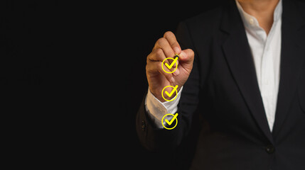Businessman holding a pen and checking a mark on the boxes symbol is one of three options while...