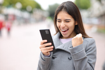 Excited woman checking content on phone
