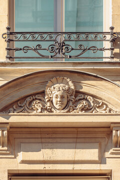 Fen&ecirc;tre et fronton sculpt&eacute; d'une fa&ccedil;ade d'immeuble haussmannien &agrave; Paris