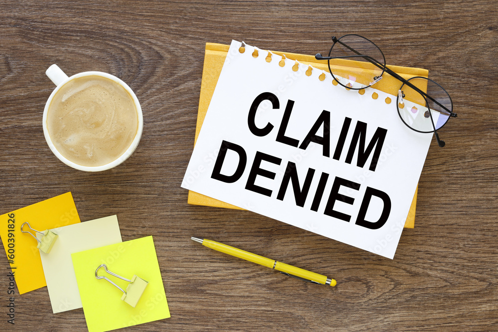 Poster cup of coffee and notepad with text claim denied