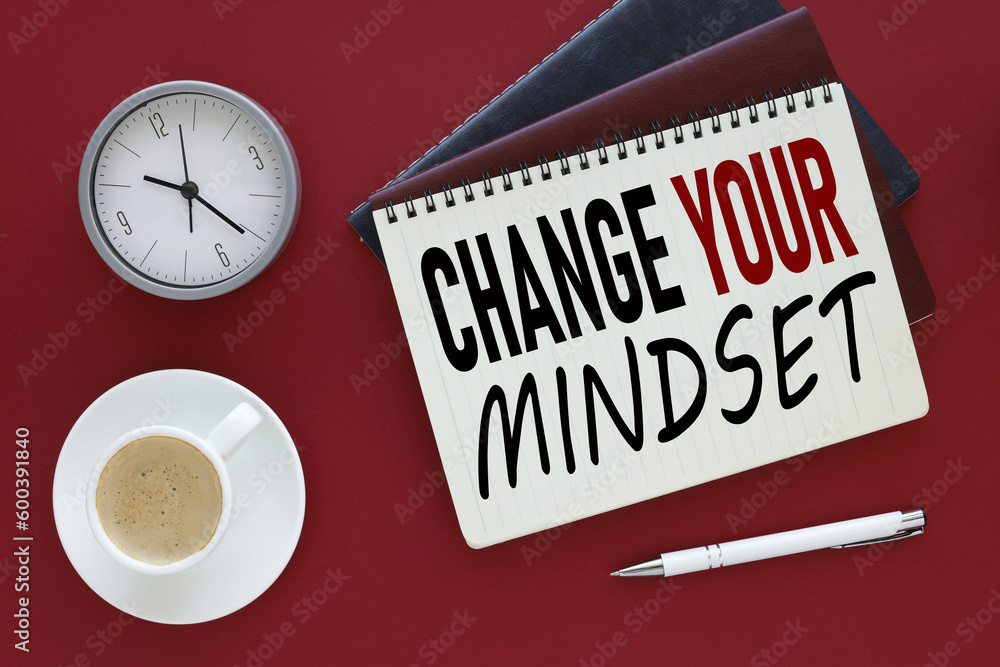 Poster bright red background with change your mindset text on paper near coffee cup and table clock