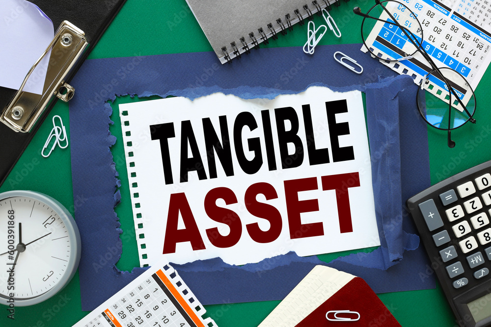 Poster tangible asset text written on paper near calendar, desk clock and calculator.