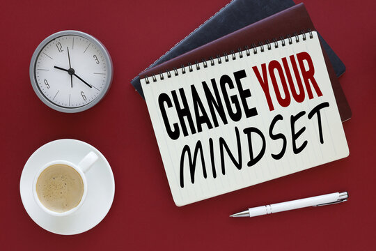 bright red background with Change Your Mindset text on paper near coffee cup and table clock