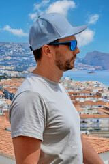 Obraz premium A man stands against the backdrop of the roofs of the old city, located on the coast of the Mediterranean