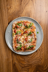 Delicious roman pizza with shrimp, arugula and parmesan on a wooden table, top view