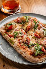 Pizza with seafood and arugula close-up