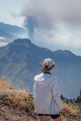 Tourist girl watching Cumbre Vieja volcanic eruption on the island of La Palma, Canary Islands....