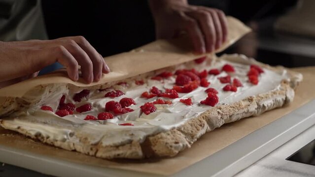 Chef's coocking a desset. Preparing a meringue roll.A beautiful and appetizing dessert meringue roll made of soft crunchy biscuit with cream