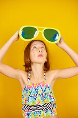 Smilling Child teenager girl in swimsuit and big sunglasses posing