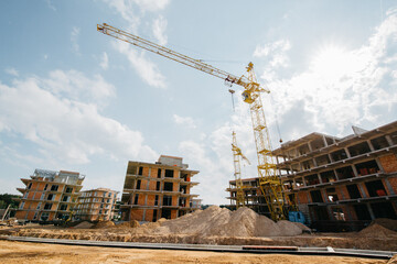 construction of luxury apartments with a construction crane against a bright sunny sky