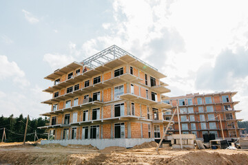 construction of a house in the forest with apartments at the final stage on a sunny day